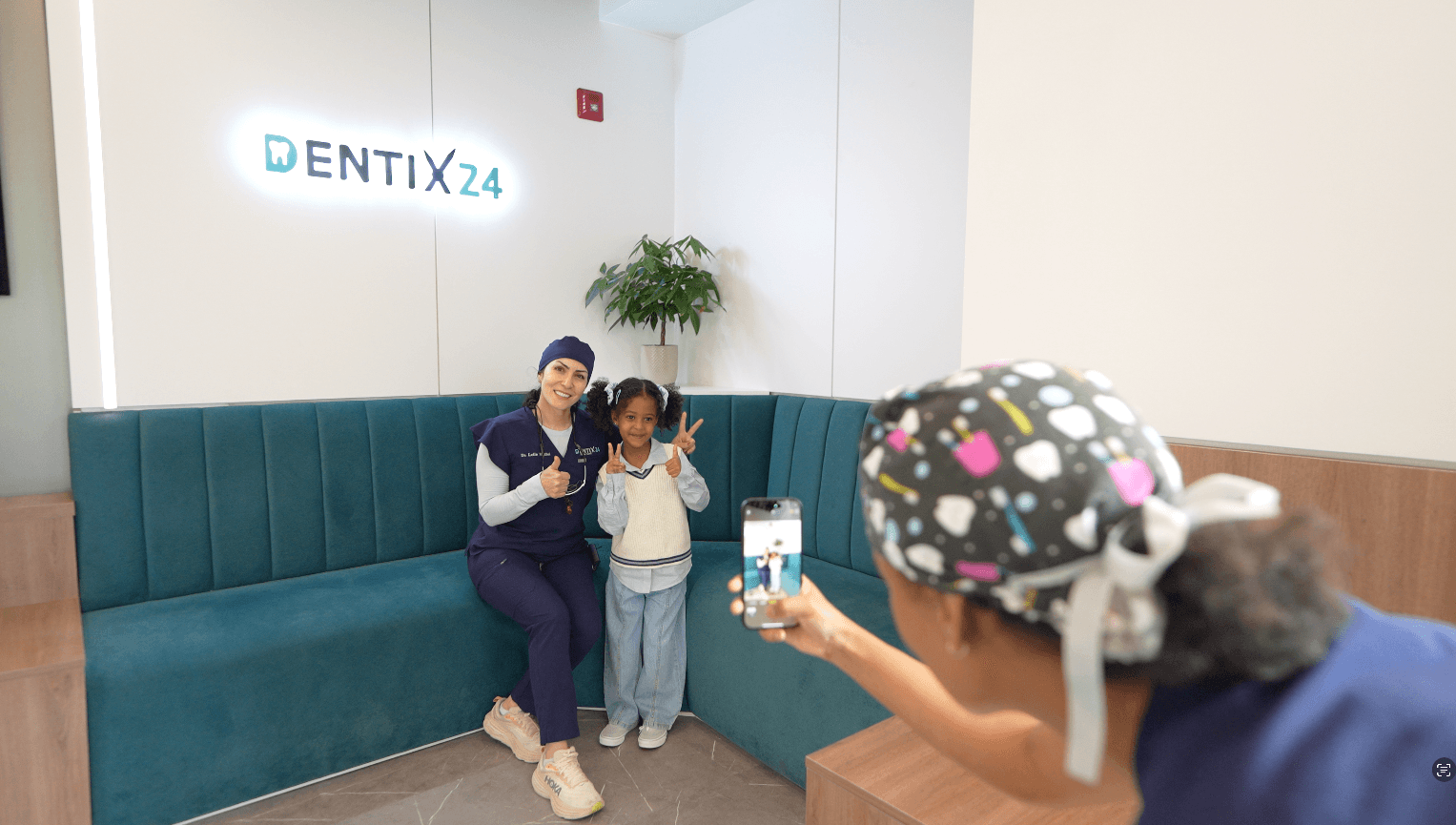 A Dentix24 team member and a young patient smiling together in the clinic